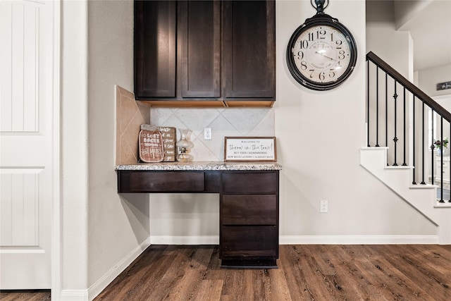 interior space with decorative backsplash, dark hardwood / wood-style flooring, dark brown cabinetry, and light stone counters