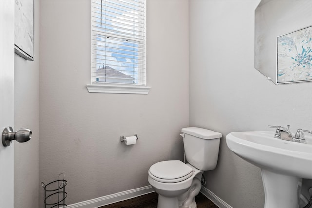 bathroom featuring toilet, wood-type flooring, and sink