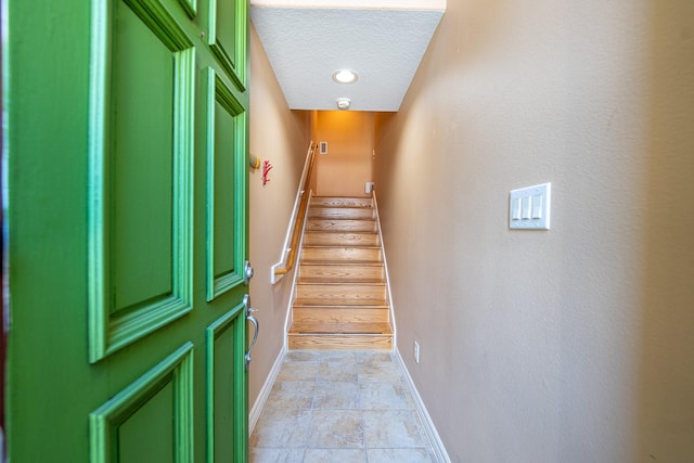 stairway with a textured ceiling