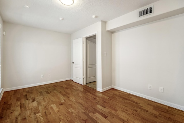 unfurnished bedroom with hardwood / wood-style flooring and a textured ceiling