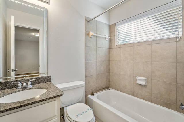 full bathroom featuring tiled shower / bath, vanity, and toilet