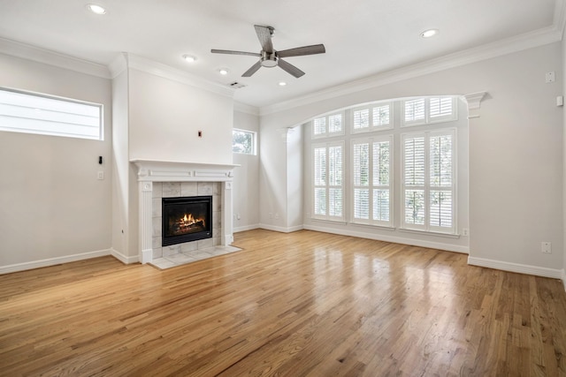 unfurnished living room with a fireplace, crown molding, light hardwood / wood-style flooring, and ceiling fan