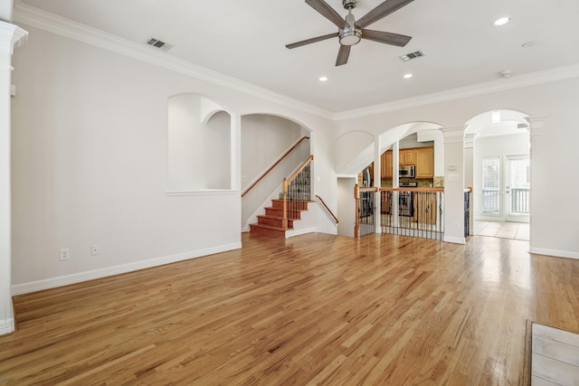 unfurnished living room featuring crown molding, ornate columns, ceiling fan, and light wood-type flooring