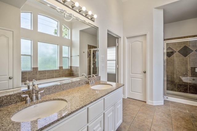 bathroom with tile patterned flooring, a wealth of natural light, and a shower with door