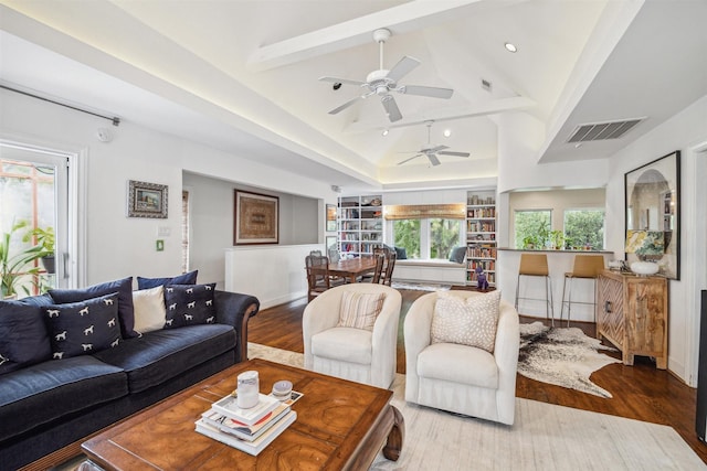 living room with hardwood / wood-style flooring, vaulted ceiling with beams, and ceiling fan