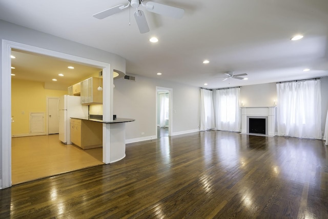 unfurnished living room featuring ceiling fan and dark hardwood / wood-style flooring