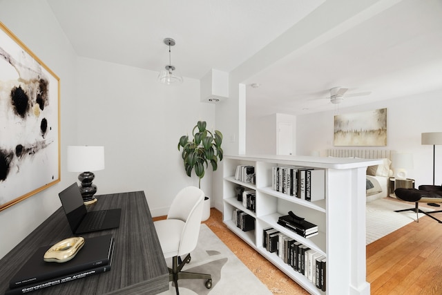 office with light wood-type flooring and ceiling fan