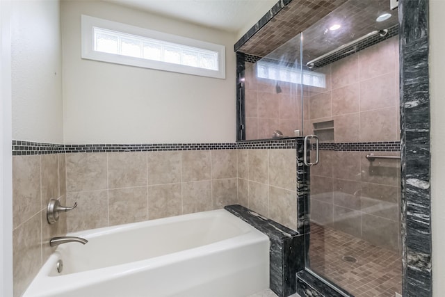 bathroom featuring shower with separate bathtub