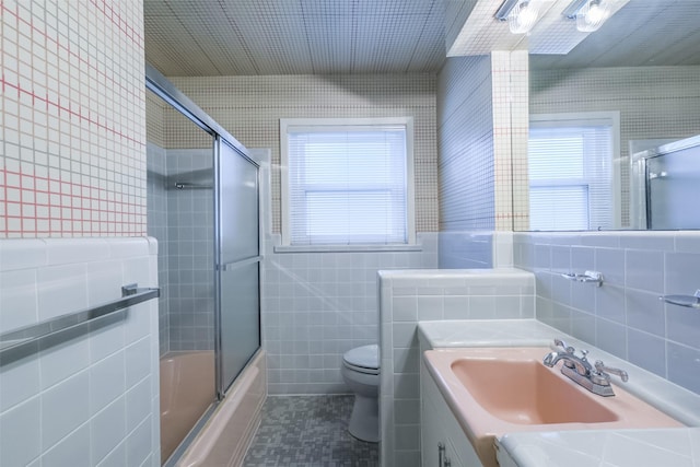 full bathroom with plenty of natural light, vanity, tile walls, and toilet