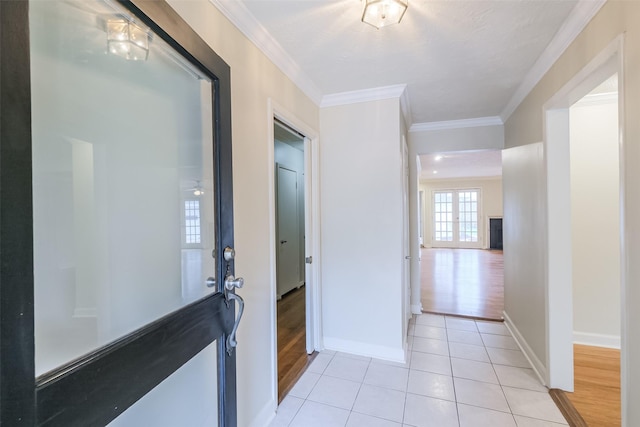 corridor with light hardwood / wood-style floors and ornamental molding