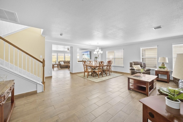 living room featuring ceiling fan with notable chandelier, ornamental molding, a textured ceiling, and light hardwood / wood-style flooring