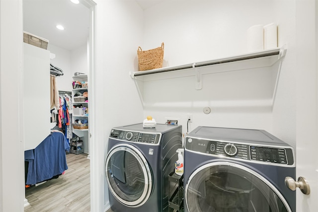 laundry area with independent washer and dryer and light hardwood / wood-style flooring