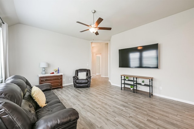 living room featuring ceiling fan, light hardwood / wood-style floors, and lofted ceiling