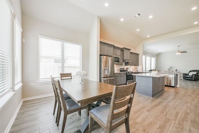 dining room with vaulted ceiling, light hardwood / wood-style flooring, and ceiling fan