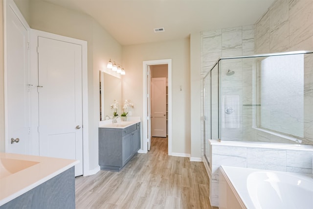 bathroom featuring hardwood / wood-style floors, vanity, and separate shower and tub