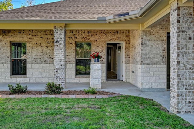 view of exterior entry with a yard