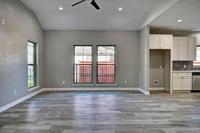 kitchen with stainless steel dishwasher, a healthy amount of sunlight, and white cabinets