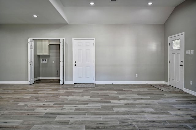 foyer featuring light hardwood / wood-style flooring and vaulted ceiling