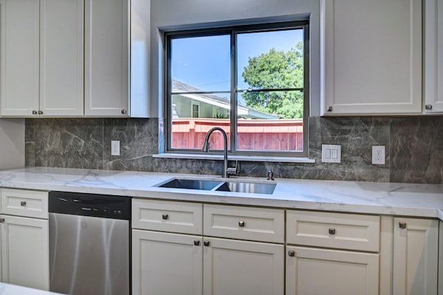 kitchen featuring sink, tasteful backsplash, stainless steel dishwasher, light stone countertops, and white cabinets