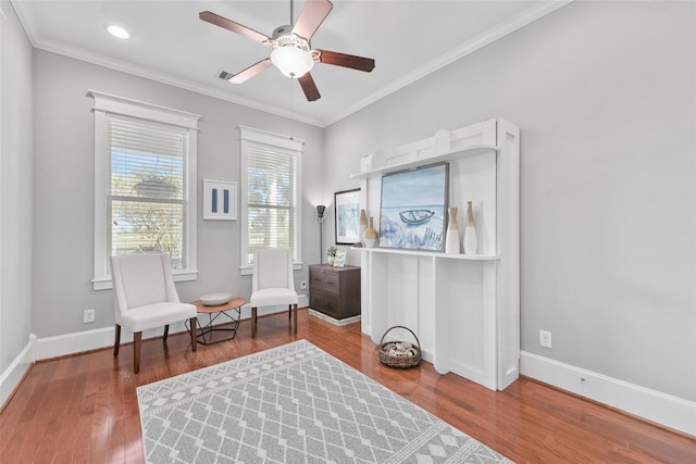 sitting room with wood-type flooring, ceiling fan, and crown molding