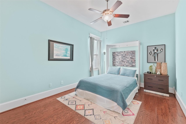 bedroom with dark hardwood / wood-style floors and ceiling fan