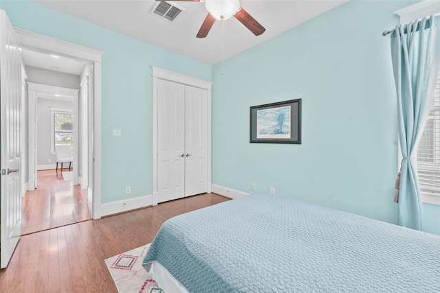 bedroom with ceiling fan, light wood-type flooring, and a closet