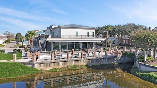 back of property featuring a water view and a balcony