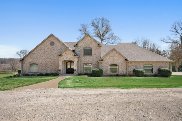 french country home featuring a front lawn