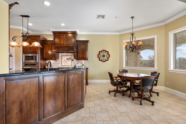 kitchen with backsplash, an inviting chandelier, hanging light fixtures, ornamental molding, and stainless steel appliances