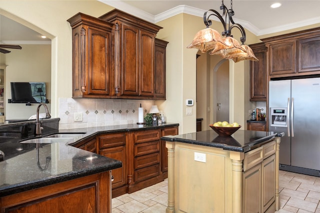 kitchen featuring stainless steel fridge with ice dispenser, sink, a kitchen island, and dark stone counters