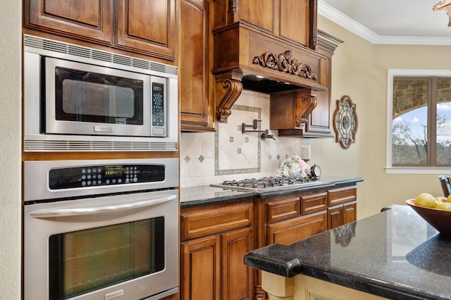 kitchen with dark stone counters, decorative backsplash, stainless steel appliances, and ornamental molding