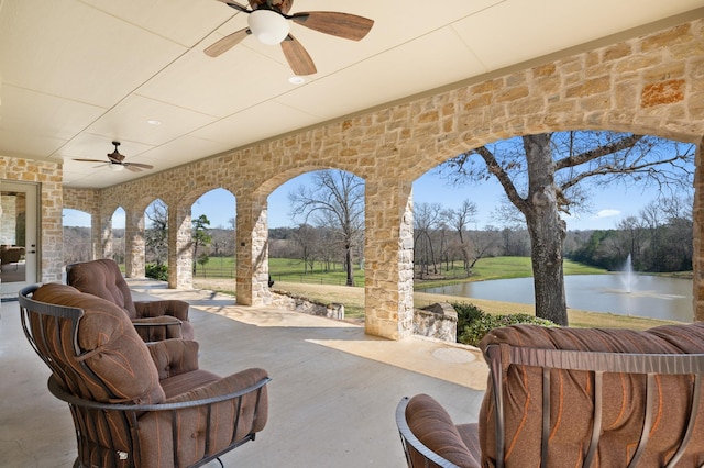 view of patio / terrace with ceiling fan and a water view