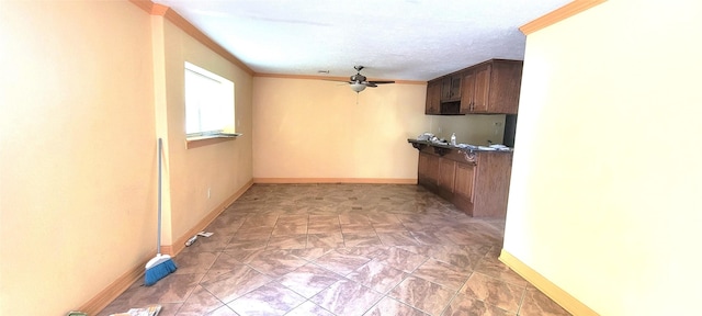 kitchen with a textured ceiling, ceiling fan, and crown molding