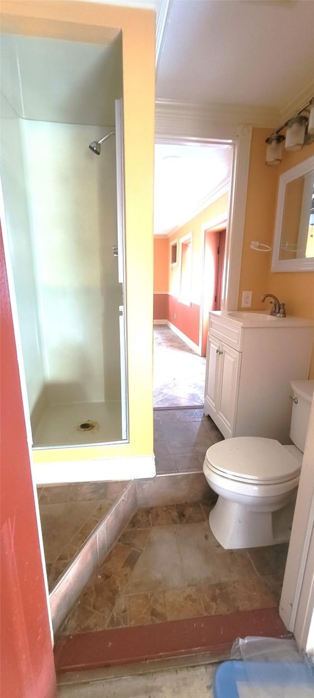 bathroom featuring toilet, vanity, ornamental molding, and walk in shower