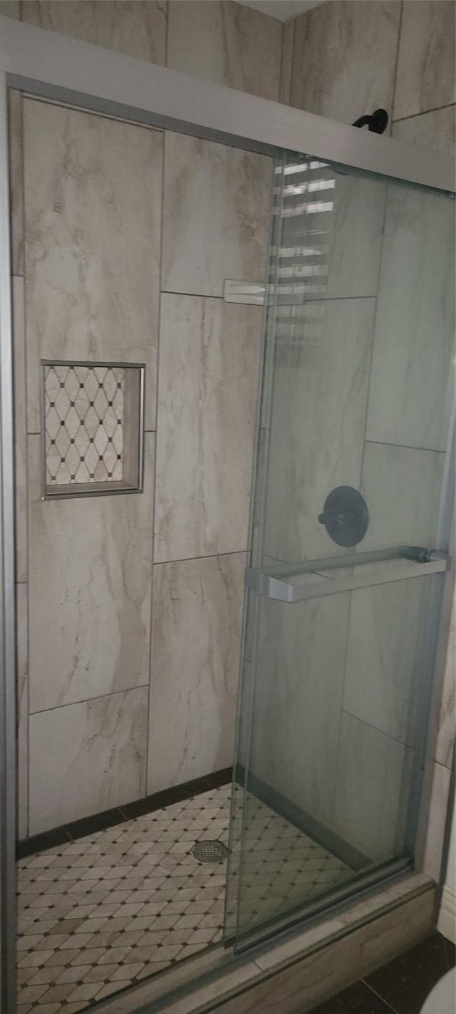 bathroom with tile patterned flooring and walk in shower