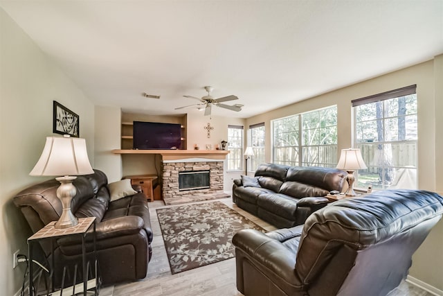 living room with a fireplace, light hardwood / wood-style floors, and ceiling fan