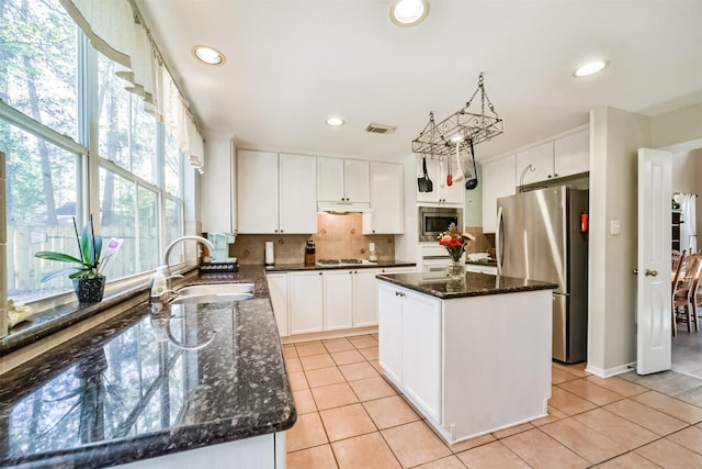 kitchen with a center island, stainless steel appliances, plenty of natural light, and sink