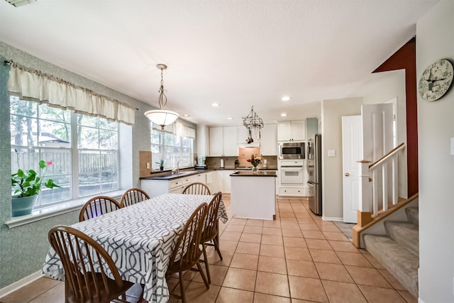 dining area featuring sink and light tile patterned floors