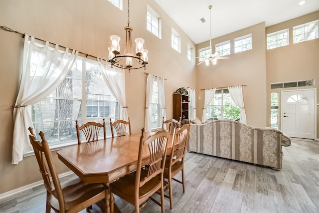 dining room featuring light hardwood / wood-style floors, a towering ceiling, and a wealth of natural light