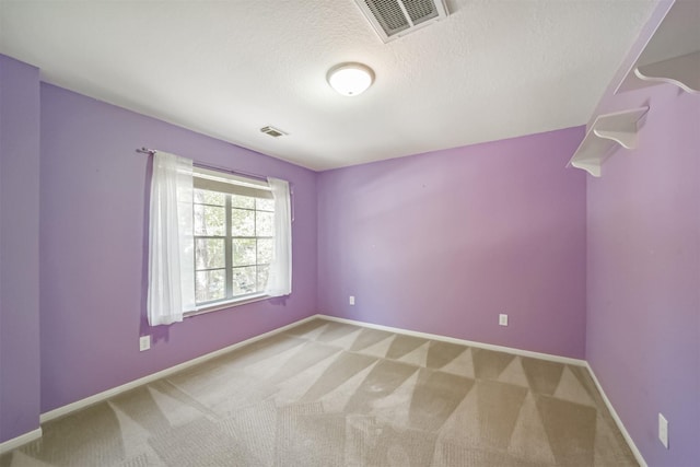 carpeted spare room featuring a textured ceiling