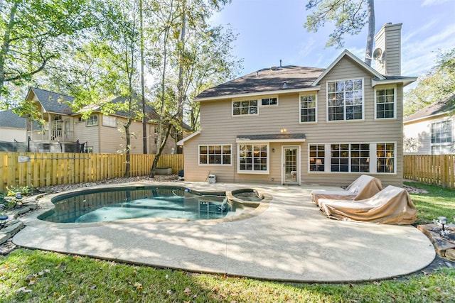 rear view of house featuring a pool with hot tub and a patio area