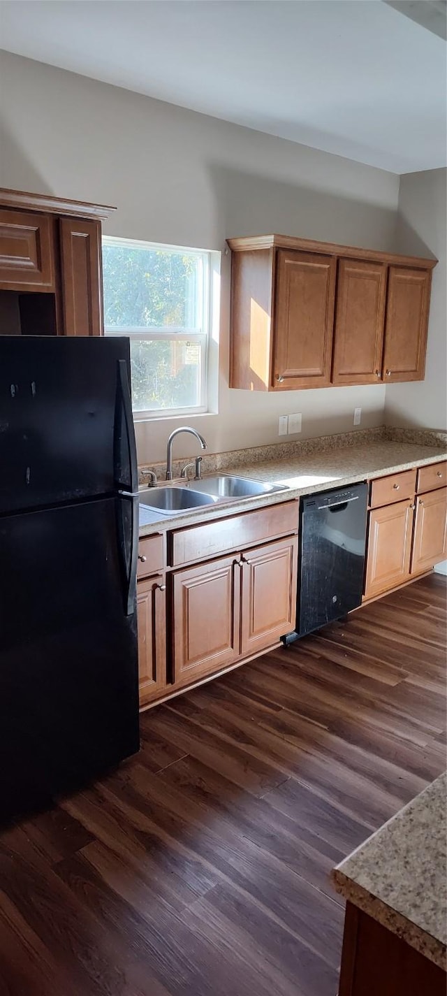 kitchen with dark wood-type flooring, black appliances, and sink