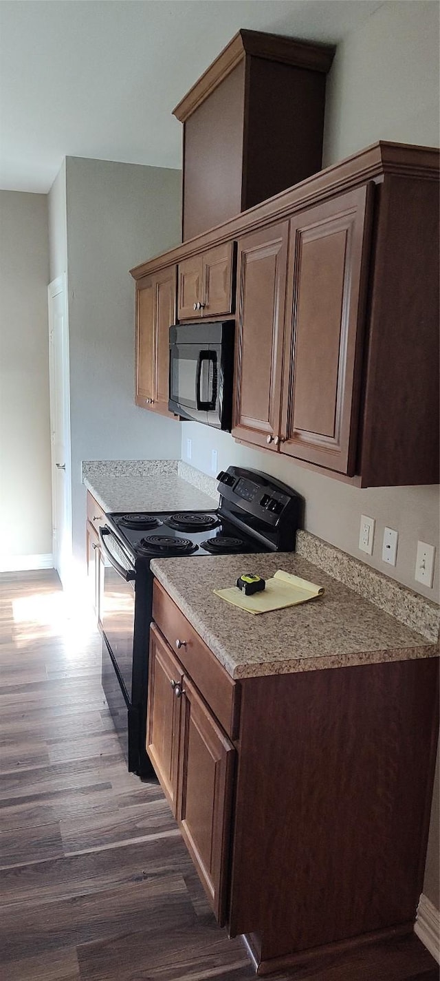 kitchen with dark wood-type flooring and black appliances