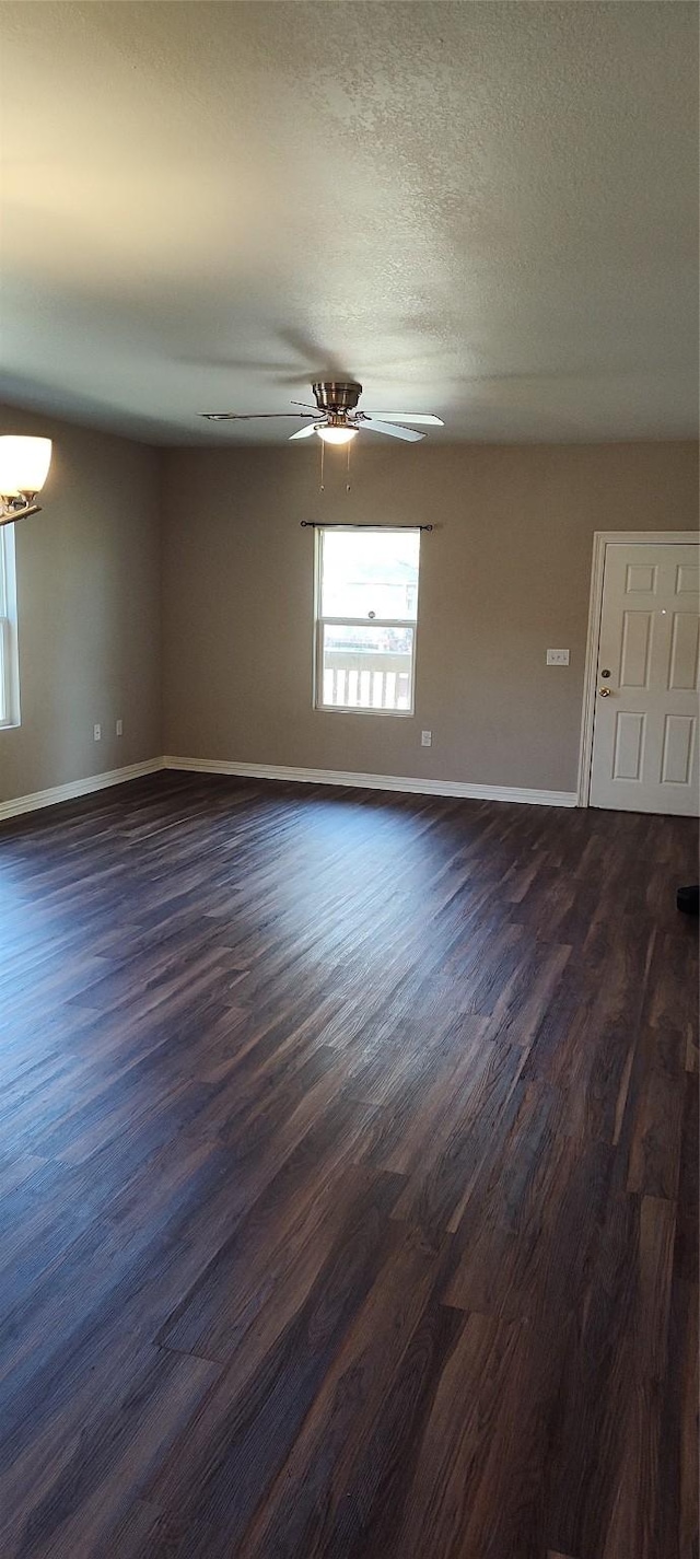 empty room with a textured ceiling, dark hardwood / wood-style flooring, and ceiling fan