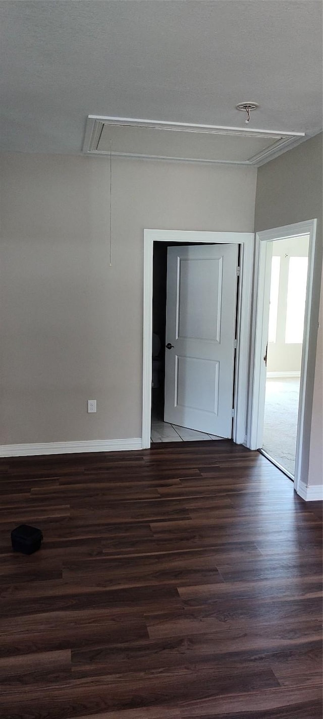 spare room featuring dark hardwood / wood-style flooring and a textured ceiling