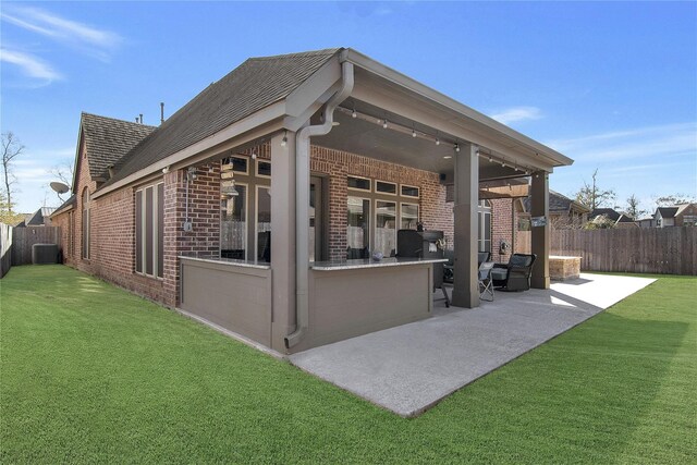 back of house featuring a lawn, a patio area, and central air condition unit