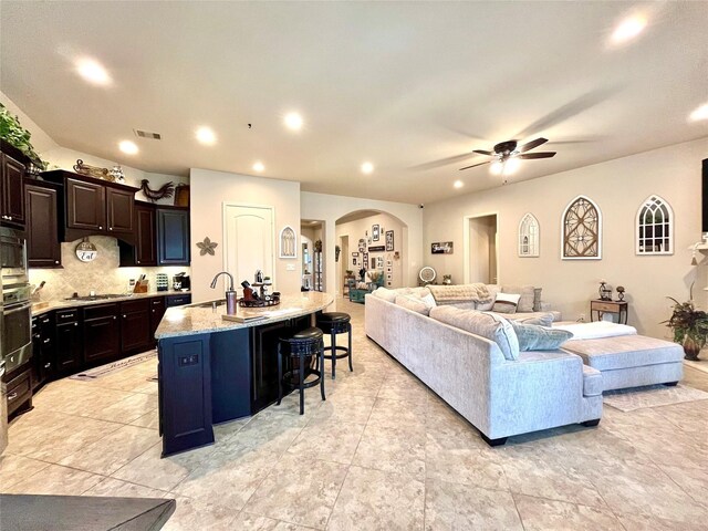 living room with ceiling fan and sink