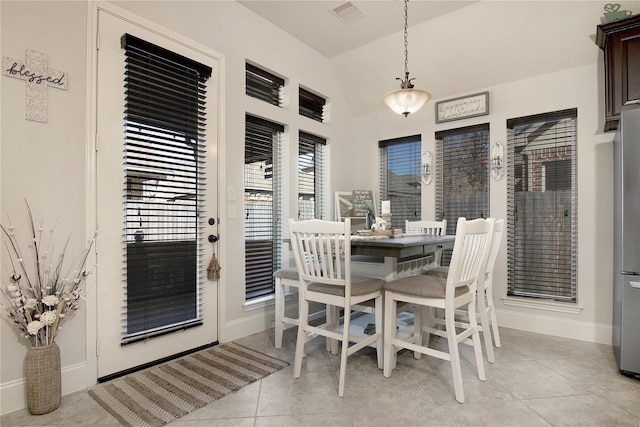 tiled dining area featuring lofted ceiling