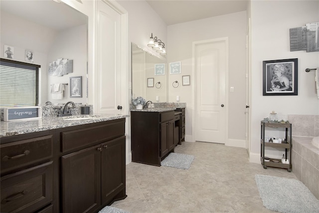 bathroom with tiled bath, tile patterned flooring, and vanity