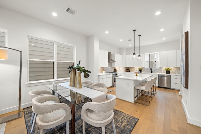 dining space with sink and light wood-type flooring